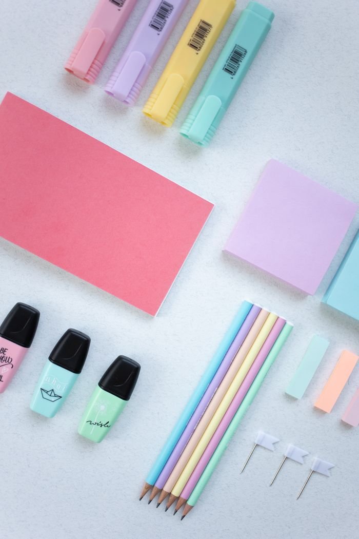 hero-img-01 An artistic flat lay of colorful stationery items on a white surface, perfect for school and office themes.
